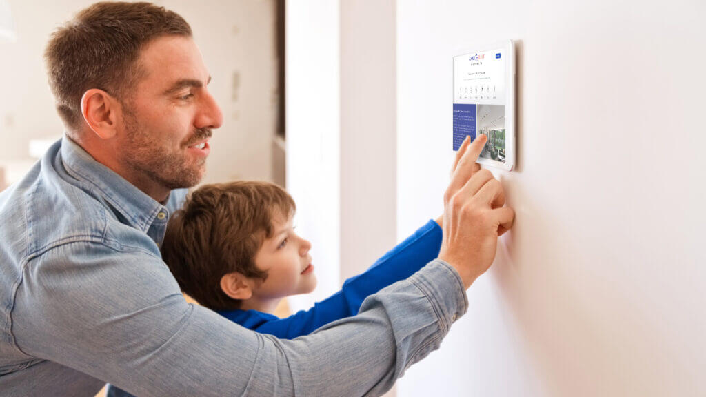 Father and Son using wall mounted tablet